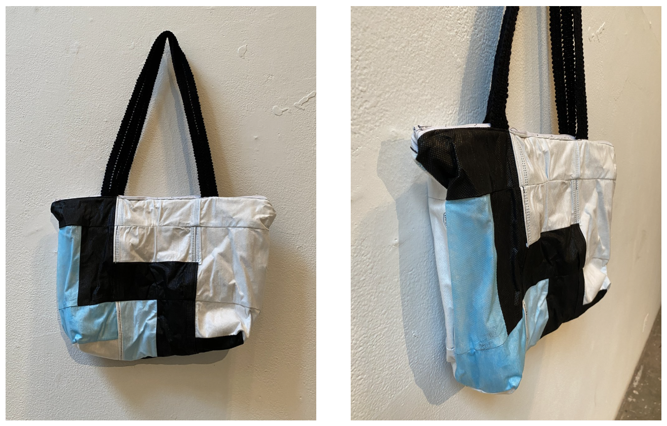 A multi-colored tote bag made from medical masks hangs from a white wall.